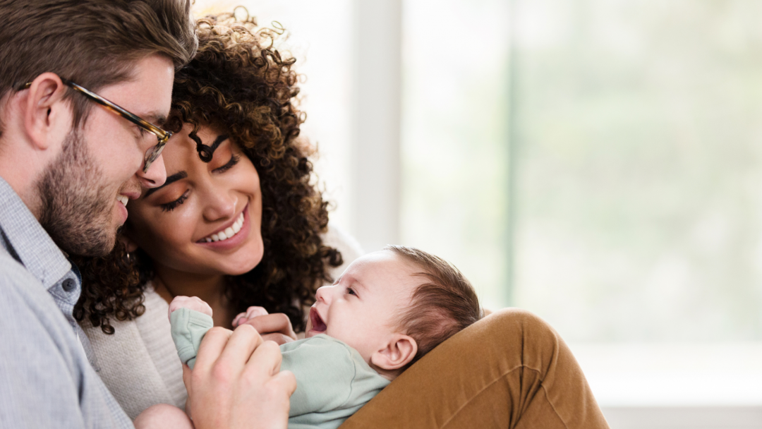 Smiling parents cuddling their infant, symbolizing flexible education savings and future planning.