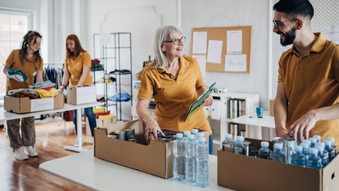 Volunteers organizing donations and bottled water at a nonprofit, symbolizing strategic philanthropy.